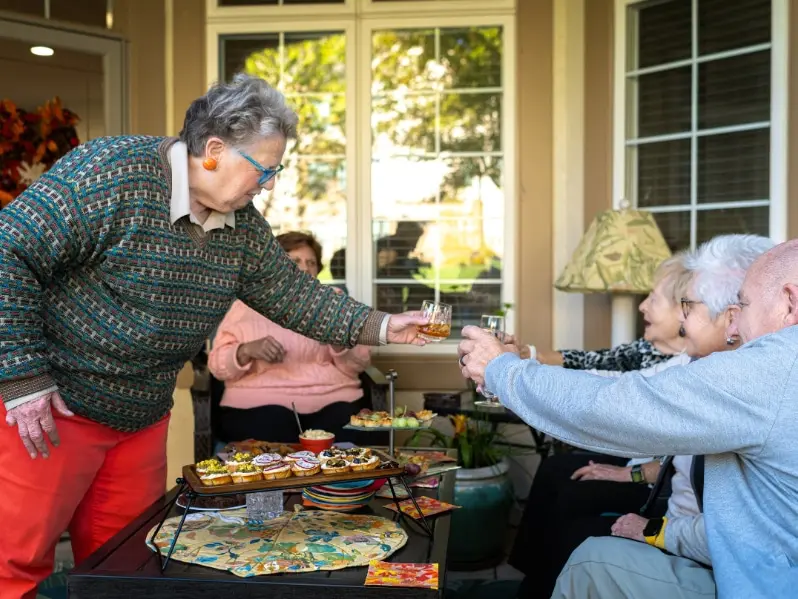 Group of residents cheersing drinks on patio