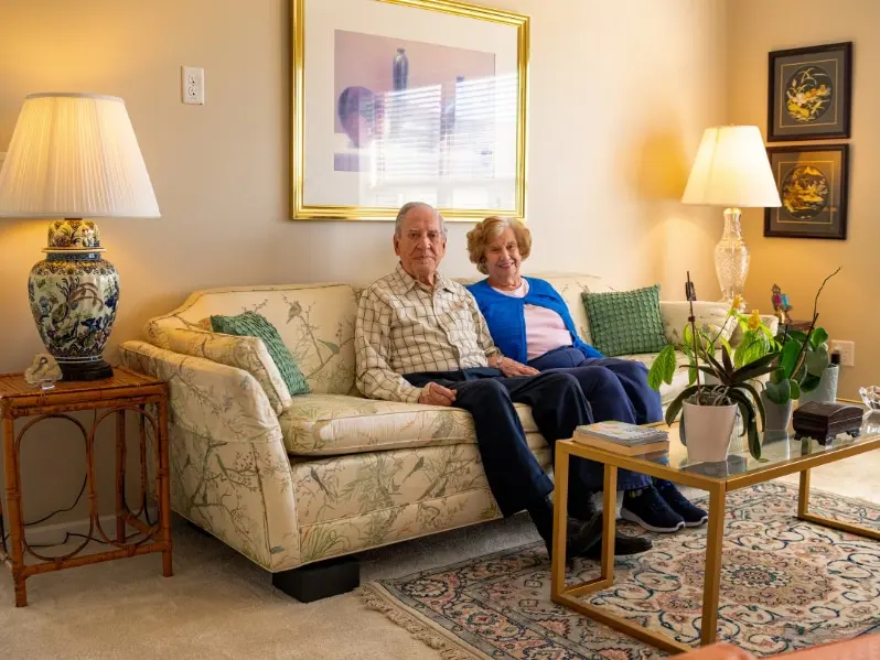 Two residents sitting on the couch in their apartment