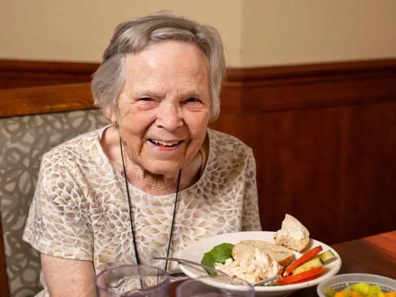 smiling elderly woman with a plate of food