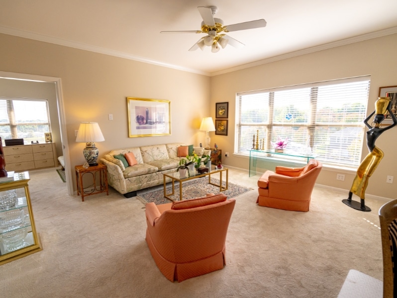 Living room of an assisted living apartment showing a couch, two chairs, and a sculpture