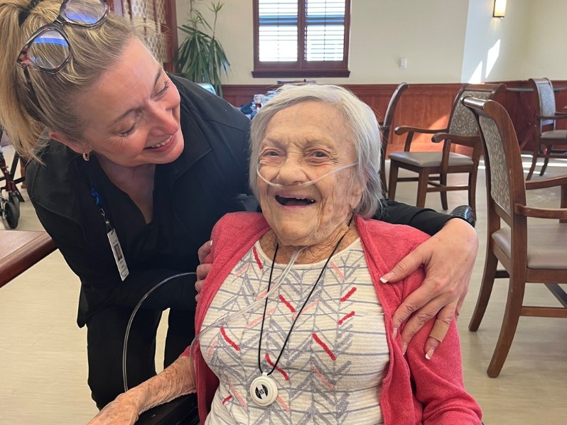 A Village Shalom nurse smiling with a smiling resident