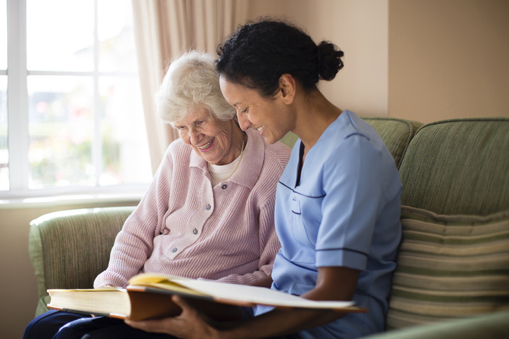 Nurse and memory care resident looking at photo album
